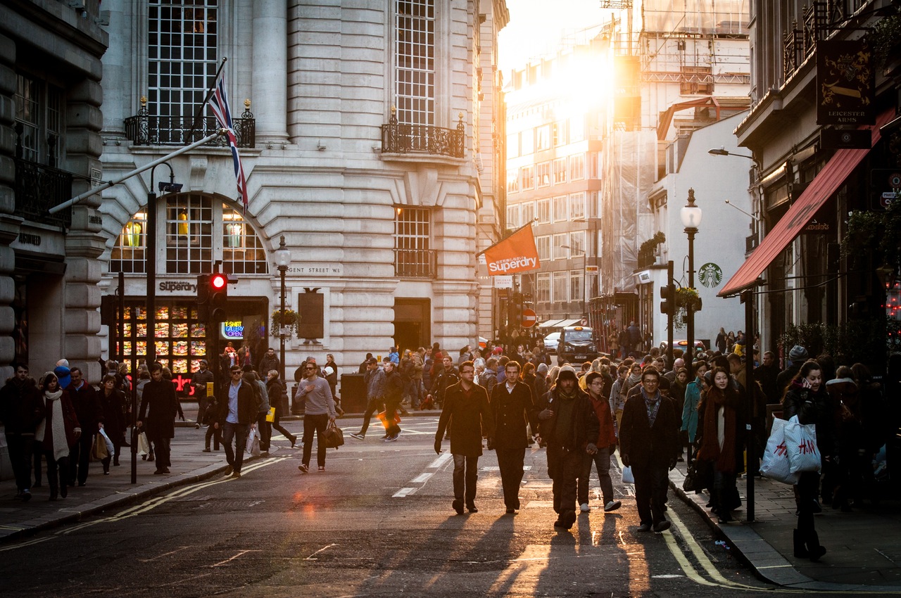 Crowded shopping street with brand names on shop signs and bags